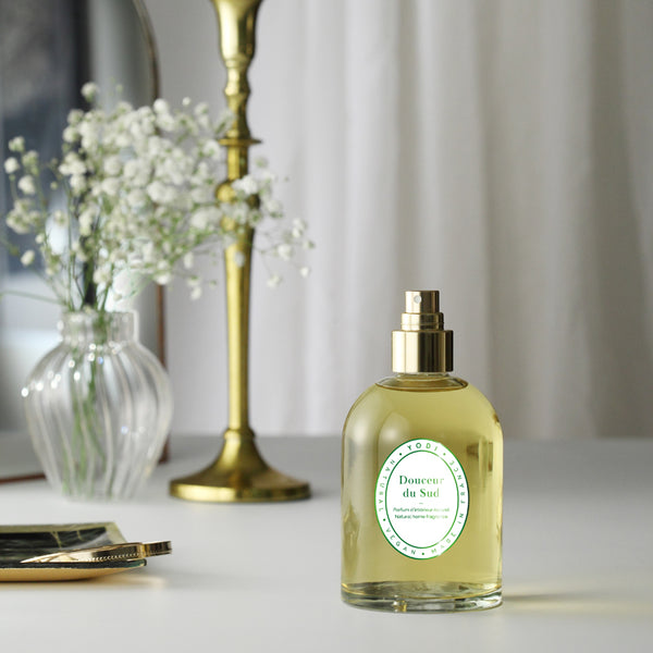 Spray parfum d'intérieur Douceur du Sud Yodi sur une table près d'un bouquet de fleurs