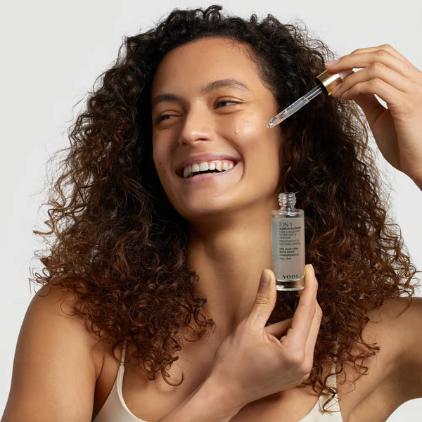 Femme souriante appliquant le Sérum Aloe Hyalurane 3-en-1 Yodi sur son visage