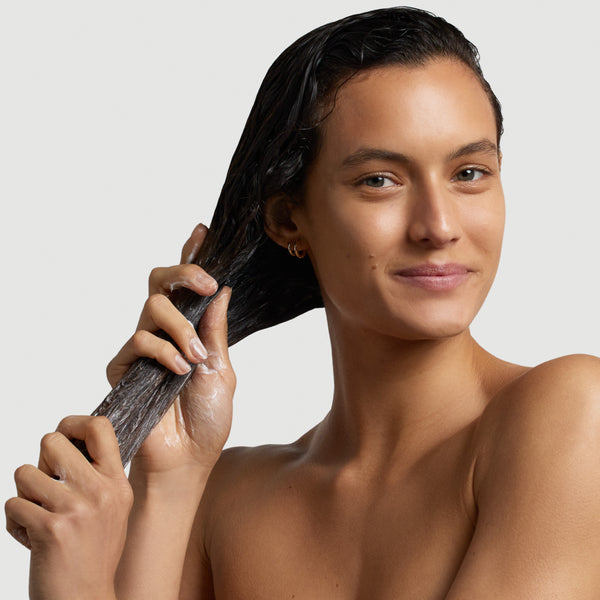 Femme appliquant le Masque Idéal Aloe Argan Yodi sur ses cheveux mouillés