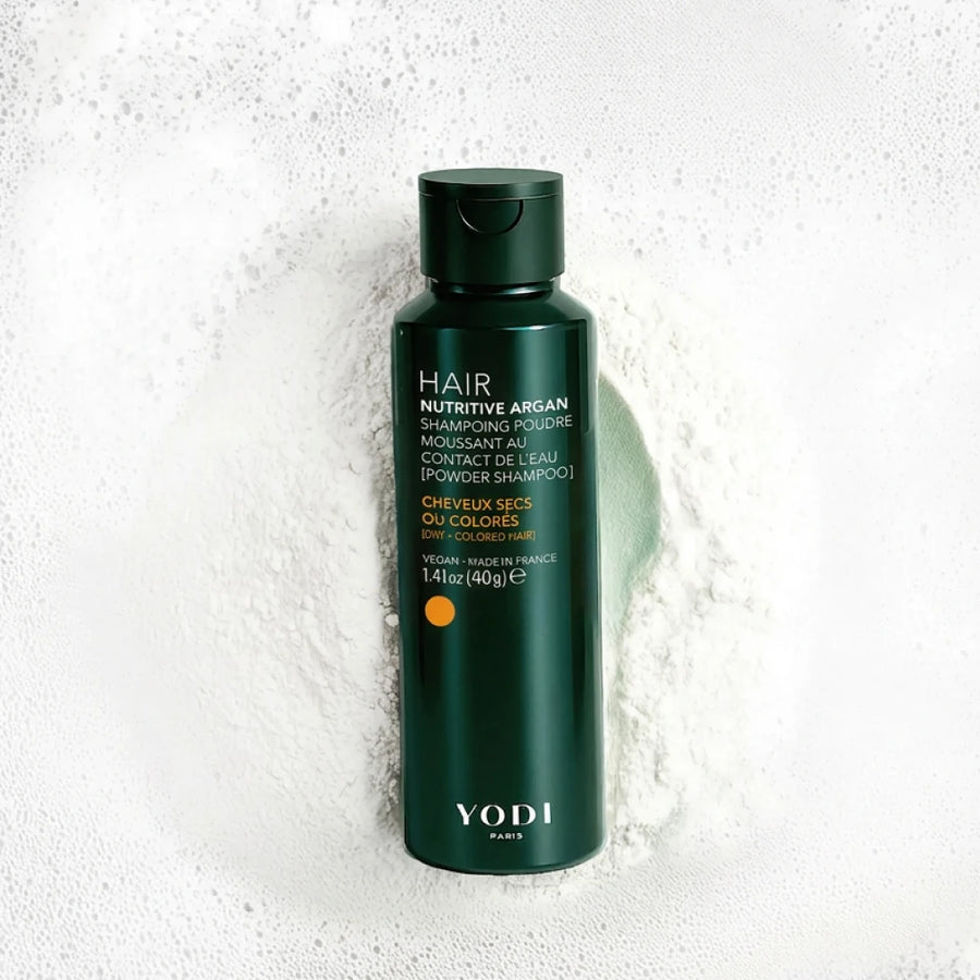 Shampoing en poudre Nutrition & Protection Yodi Nutritive Argan, flacon posé sur sa poudre et sa mousse