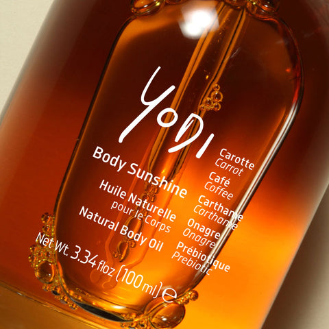 Gros plan sur le flacon d'Huile Corps Sublimatrice Body Sunshine Yodi, huile orangée